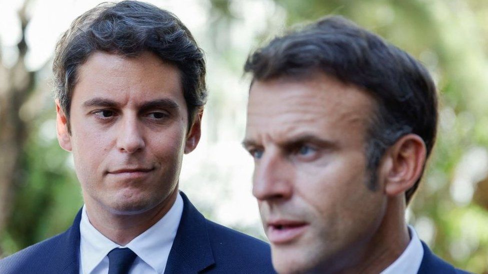 French Education and Youth Minister Gabriel Attal (L) looks at France's President Emmanuel Macron (R) addressing the audience at the 'lycée professionnel de l'Argensol' or Argensol vocational school during his visit of the school in Orange, Southeastern France on September 1, 2023