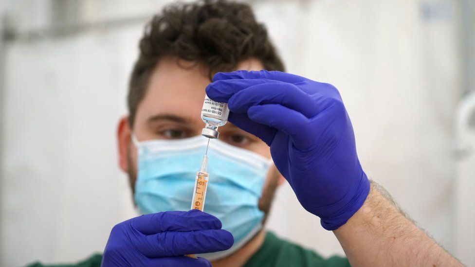 Фармацевт NHS готовит дозы вакцины AstraZeneca Covid в Уэйдбридже