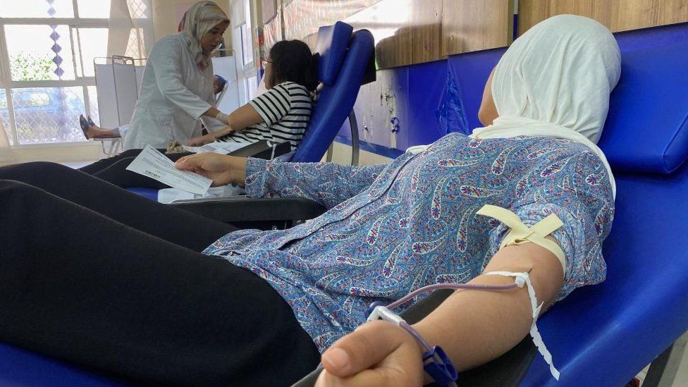 Two women donating blood in a local hospital