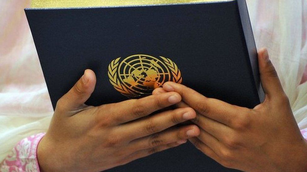 Pakistani student Malala Yousafzai hold the United Nations Charter presented to her by then UN Secretary-General Ban Ki-moon, 12 July 2013