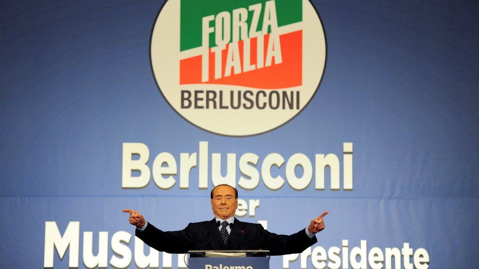 Лидер партии Forza Italia Сильвио Берлускони машет рукой во время митинга в Палермо 1 ноября
