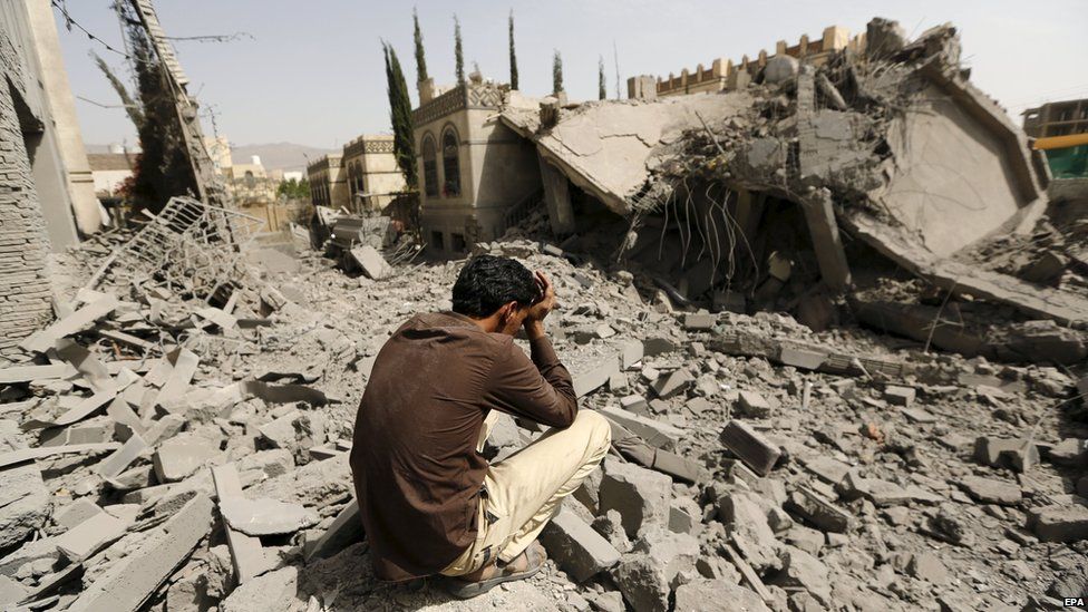 A guard sits on the rubble of the house of Brigadier Fouad al-Emad, an army commander loyal to the Houthis, after air strikes destroyed it in Sanaa, Yemen June 15, 2015