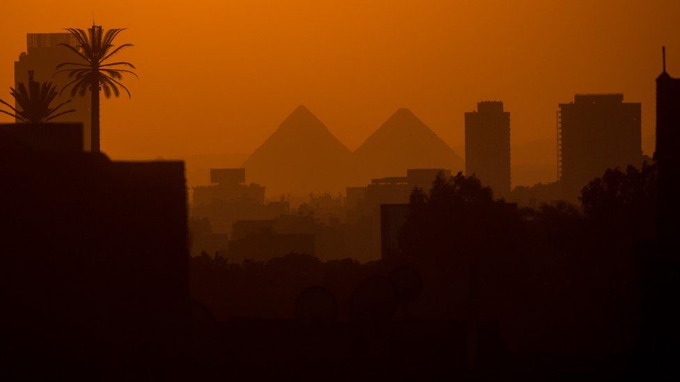 City buildings are seen in front of the famous Pyramids of Giza on 15 December 2016 in Cairo, Egypt