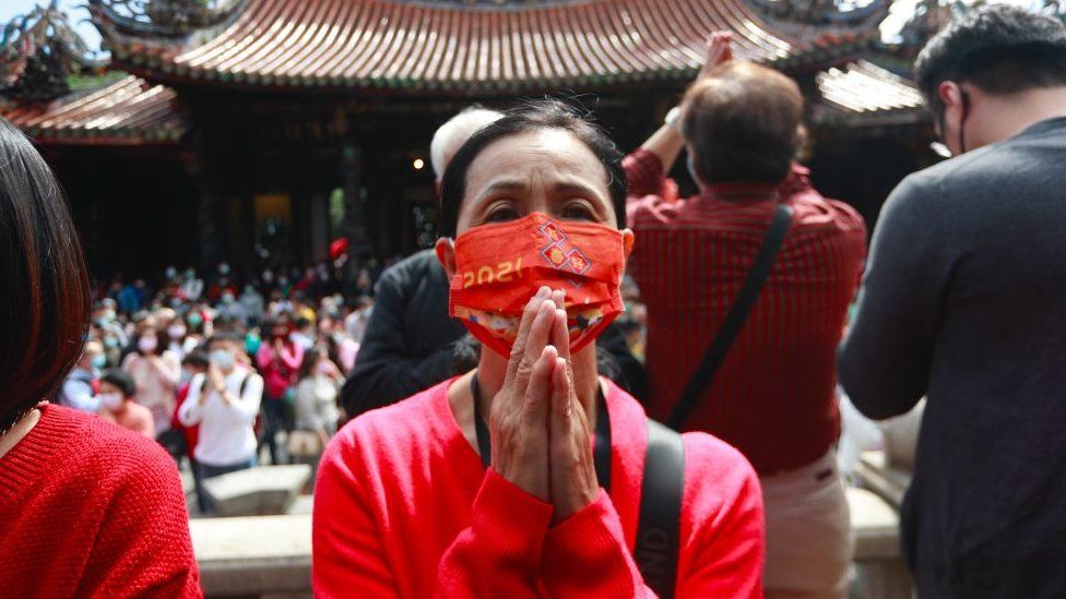 Taiwanese people wearing a face mask pay worships at Lungshan Temple