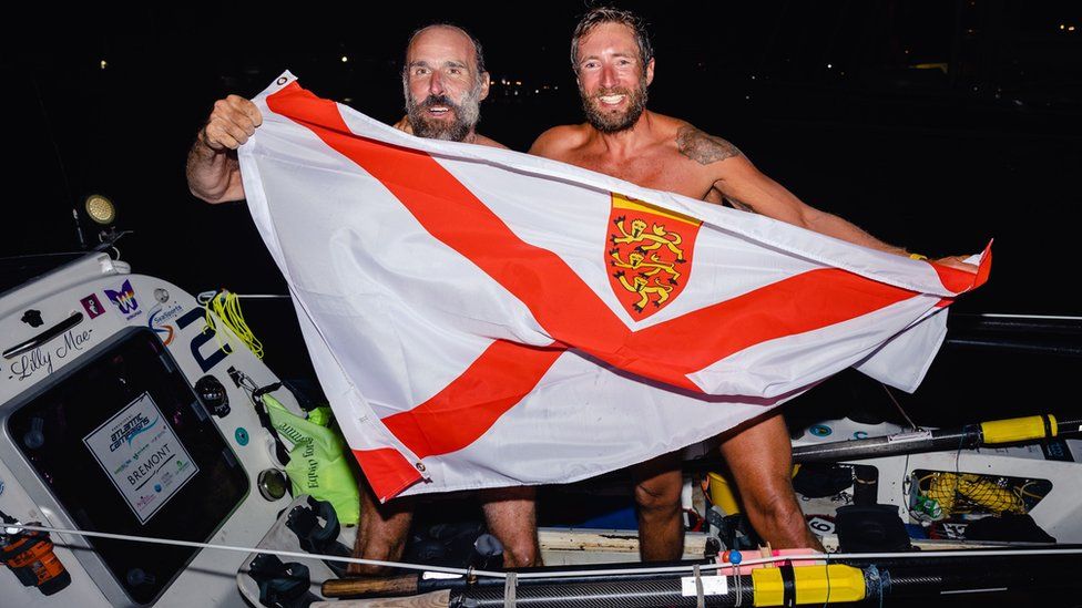 Rowers Steve Hayes and Peter Wright holding Jersey flag