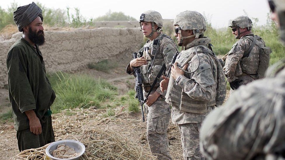 US soldiers speak through an interpreter to an Afghan farmer in Khan Neshin, Afghanistan August 15, 2009