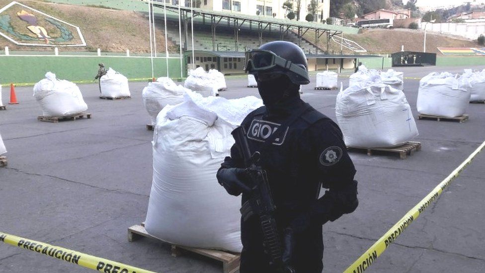 member of Bolivian special forces stands next to bags of cocaine at the police headquarters in La Paz (01 August 2016)