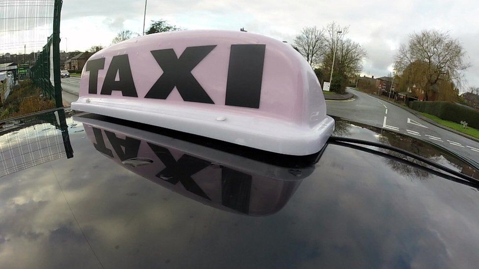 General view of a TAXI sign on the roof of a licensed mini cab