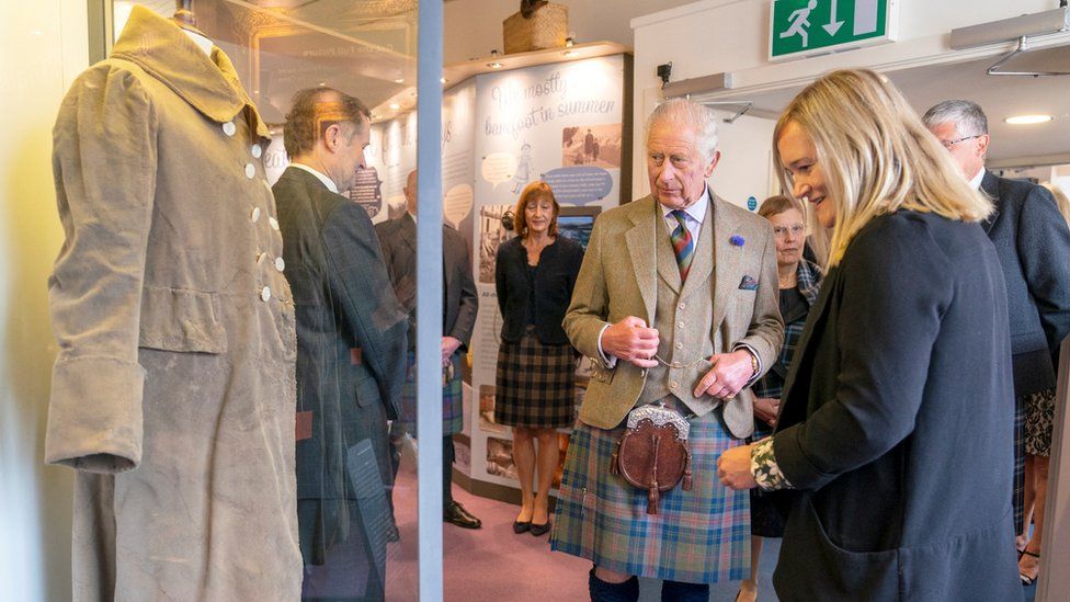 Britain's King Charles takes a look at the Tomintoul Coat during a visit to the Discovery Centre in Tomintoul