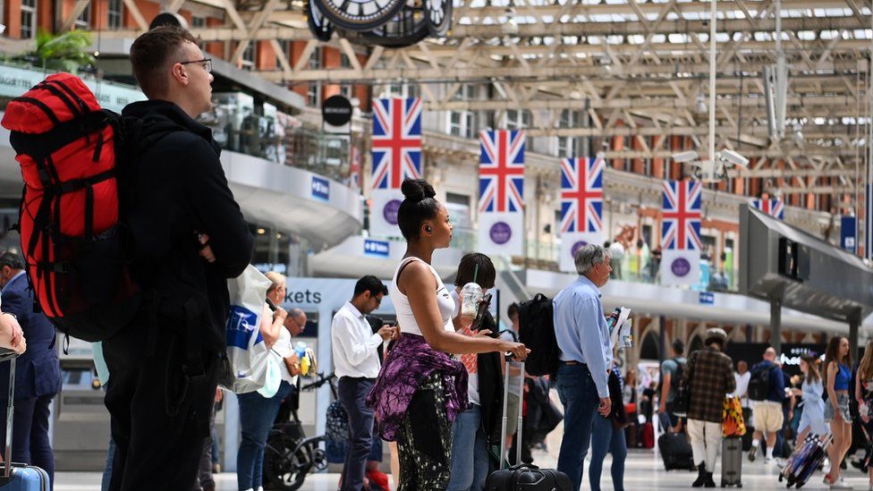 People wait for trains at London's Waterloo train station