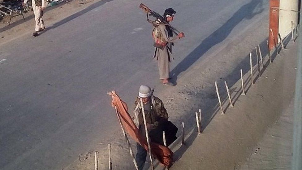 Taliban fighters walk with their weapons on a street in Kunduz, north of Kabul, Afghanistan (28 Sept 2015)