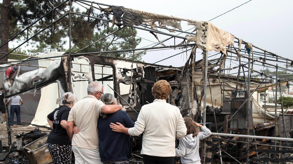 People view damage caused by fires at a camping ground in the Marinha Grande area of central Portugal