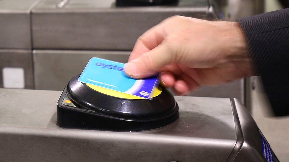 Customer using Oyster card at the ticket barrier at an underground station