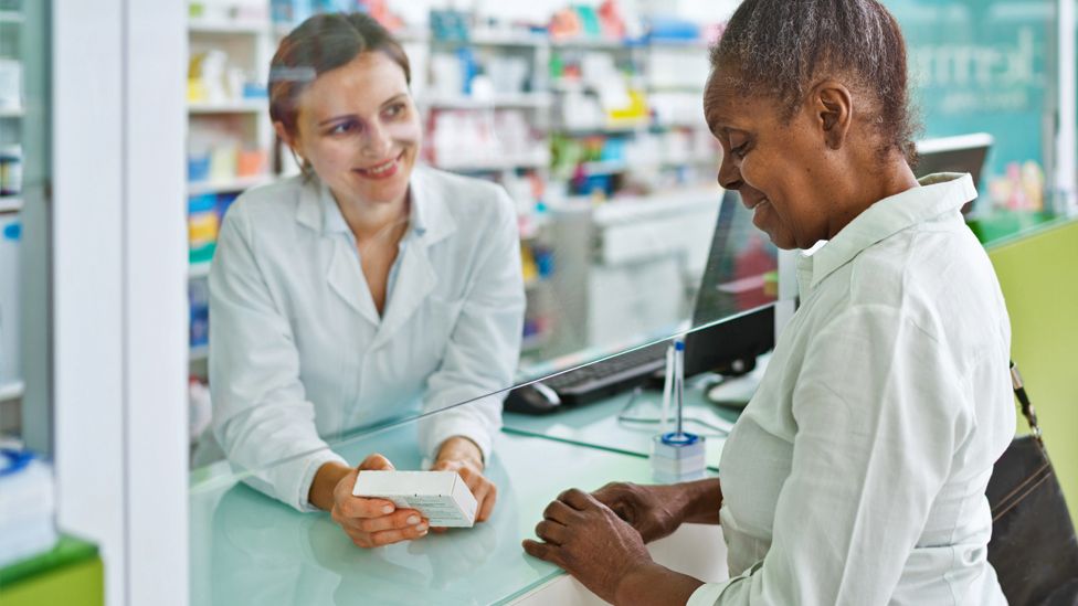 A pharmacist speaks with a customer