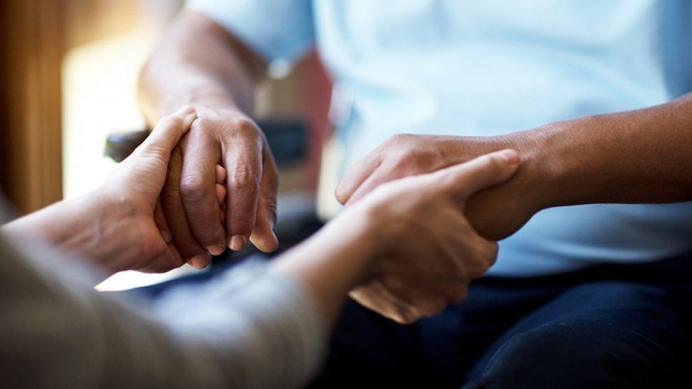 Woman holding man's hands