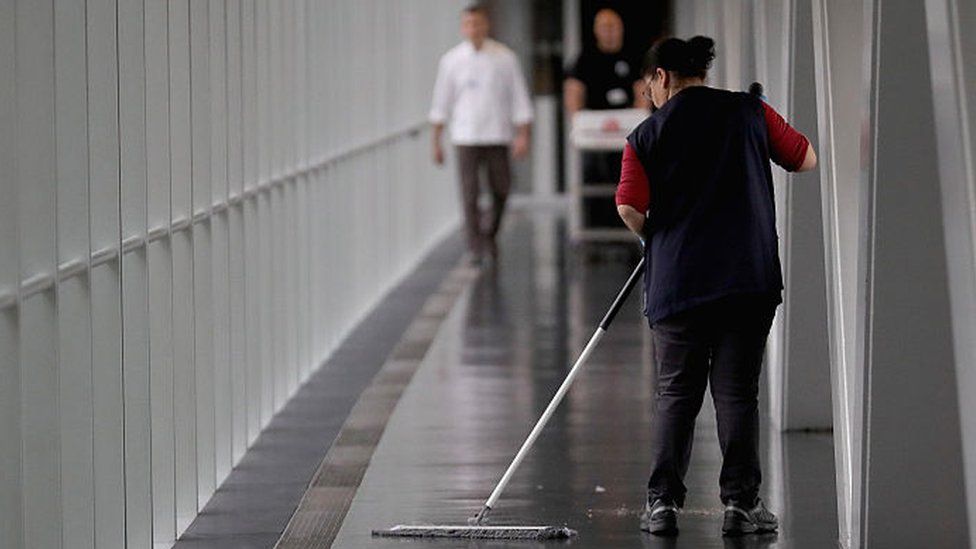 Cleaner sweeps the floor of a bridge linking the European Parliament and the Winston Churchill Building on May 12, 2016