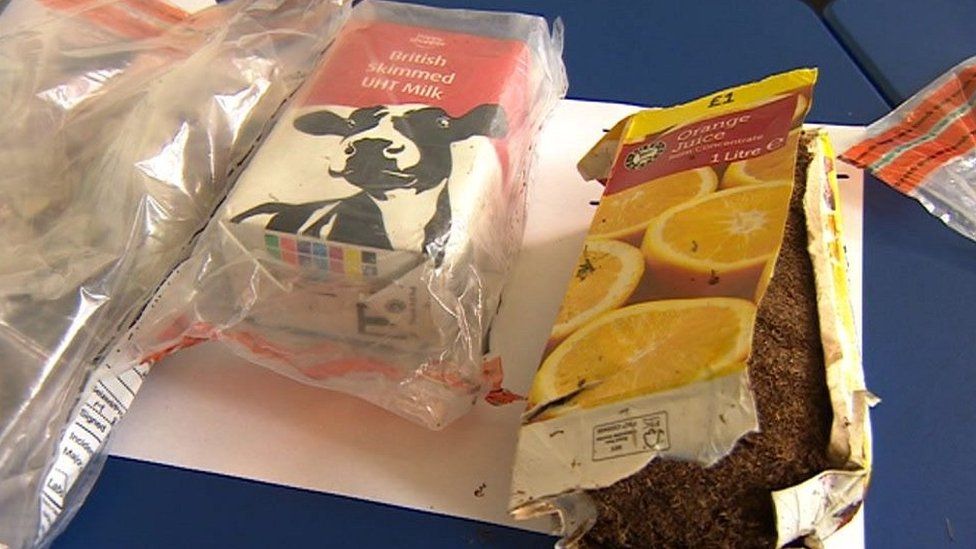 Carton of orange juice and a milk carton with smuggled contraband items hidden inside