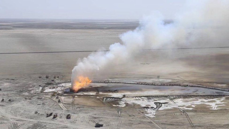 Aerial photo showing the fire and a plume of smoke emanating from the well where the blowout took place