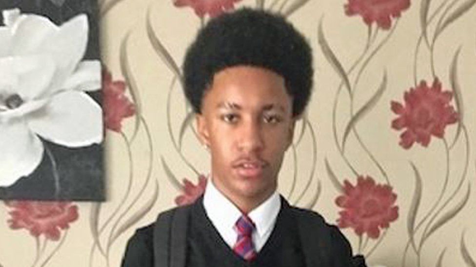 Image of Rohan Shand with long dark hair wearing a school uniform with a red tie