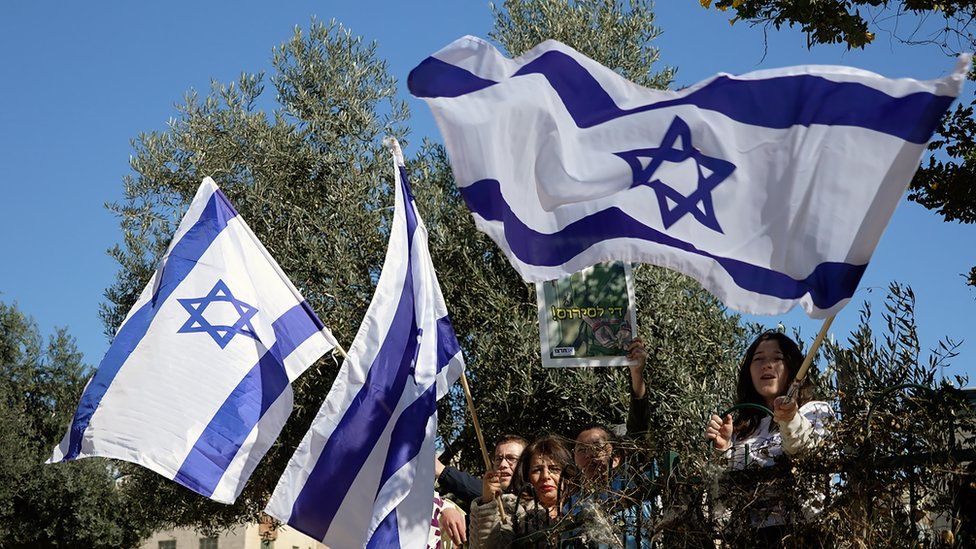 Israelis hold up Israeli flags
