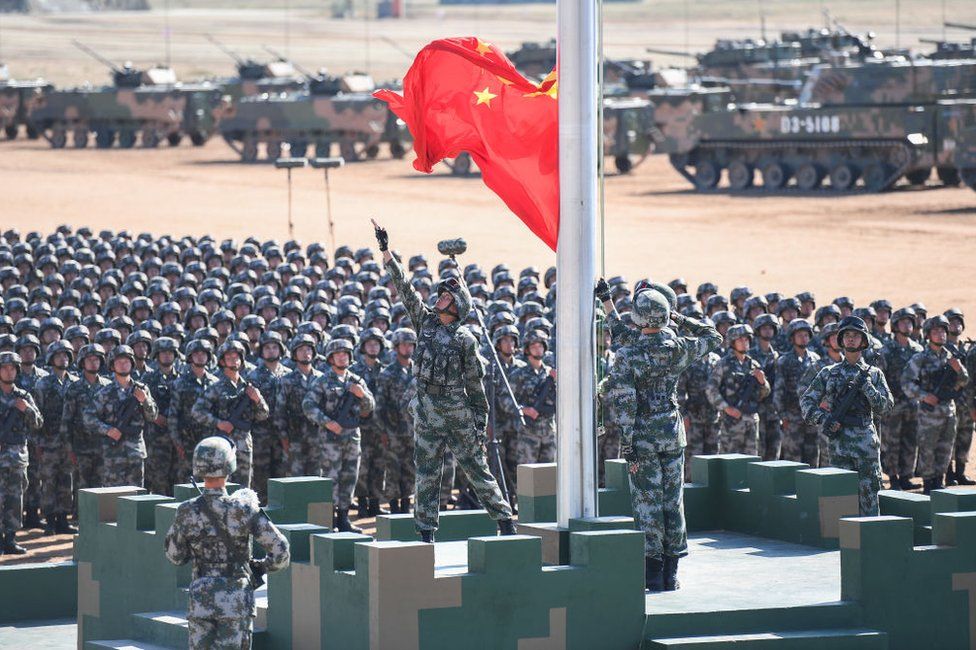The Chinese flag is raised during a military parade at the Zhurihe training base in China's northern Inner Mongolia region on 30 July 2017