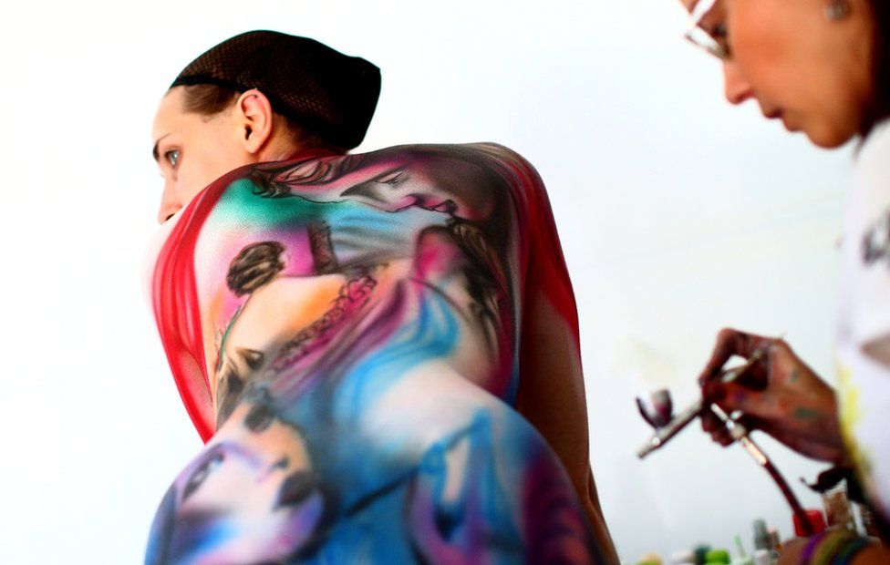 An artist paints a model during the World Bodypainting Festival 2018