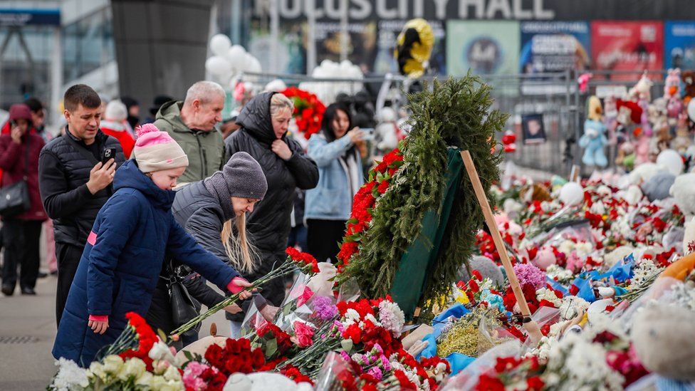 People lay flowers outside Crocus City Hall music venue in Moscow after an attack there in 2024