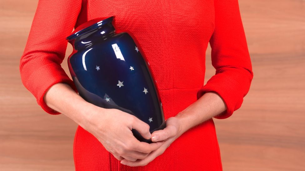 a woman holding an urn