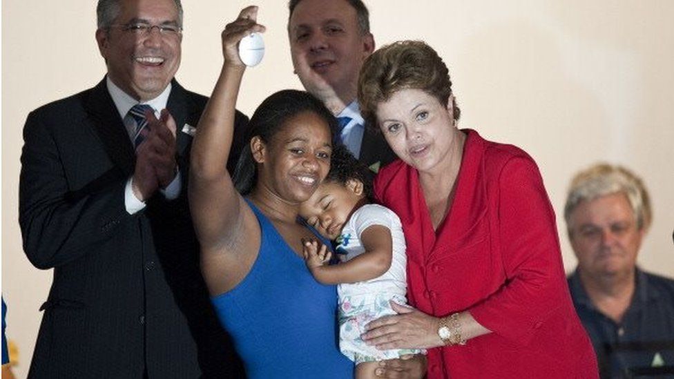 Brazil's President, Dilma Rousseff (R), poses with a benefited family during a ceremony to deliver 300 houses built by the "Minha Casa, Minha Vida" (My house, My Life) social program, in Sao Paulo, Brazil, on January 25, 2013
