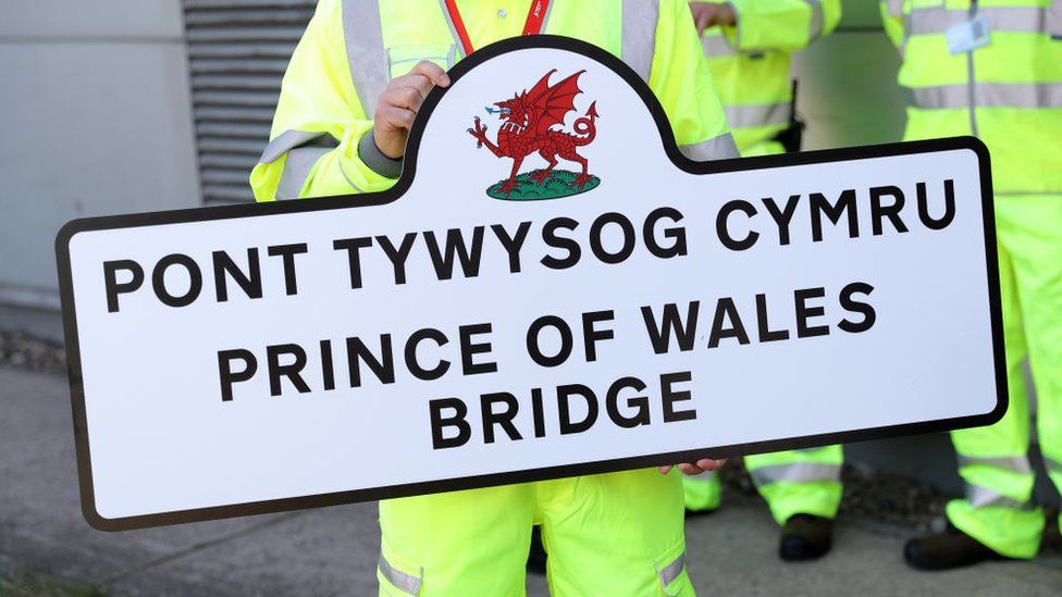 Maintenance worker holds up a sign for the Prince of Wales Bridge