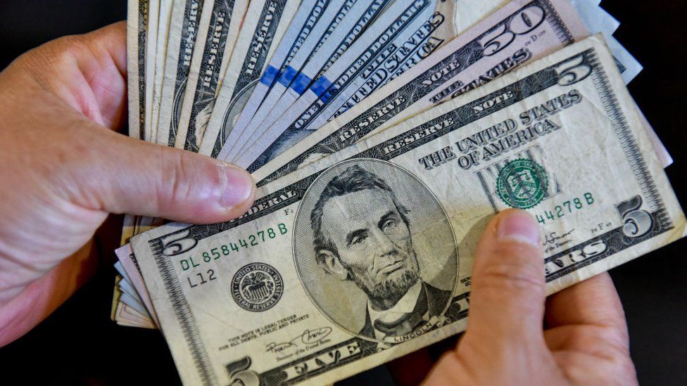 person handles US banknotes