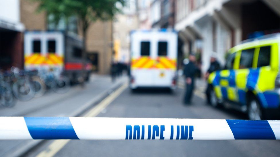 Stock image of police cars and a police cordon