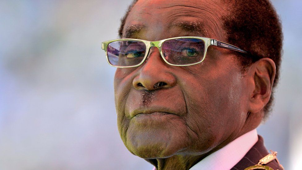 This file photo taken on August 22, 2013 shows Zimbabwean President Robert Mugabe looking on during his inauguration and swearing-in ceremony at the 60,000-seater sports stadium in Harare. Zimbabwe"s former president Robert Mugabe was ousted by a "military coup" that forced his resignation, former cabinet minister Jonathan Moyo said in an interview with the BBC broadcast on January 11, 2018. Moyo, a former higher education minister under the last president and an ardent Mugabe loyalist, said Zimbabwe"s new President Emmerson Mnangagwa stole power and was leading an "illegal regime".
