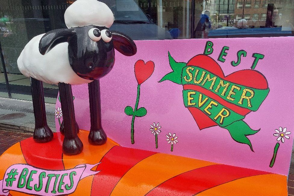 One of the smaller sheep on a bench with the words 'best summer ever'