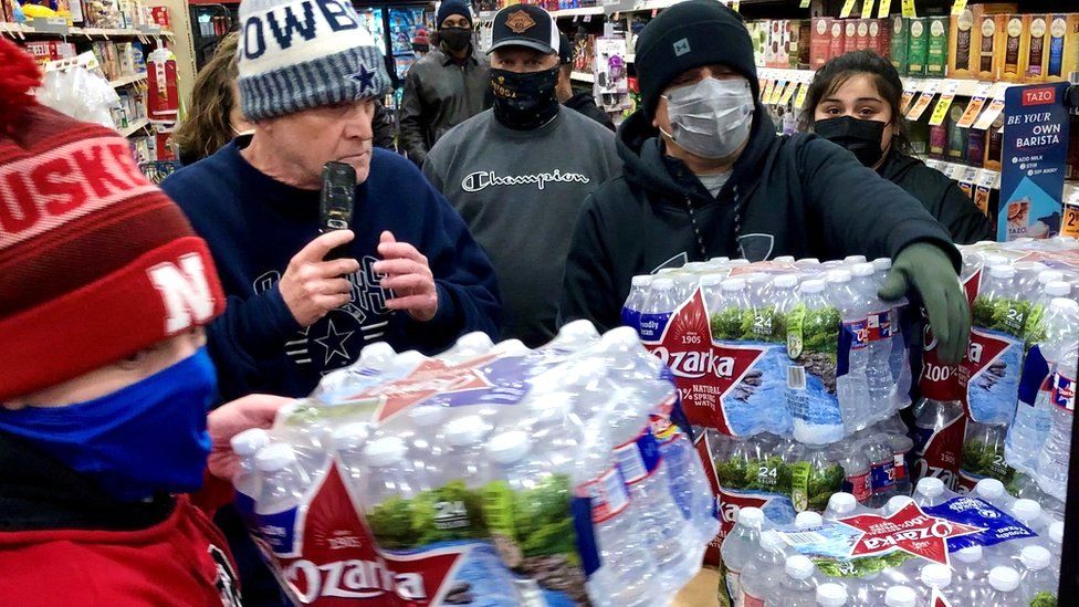 Shoppers crowd a display of bottled water at a supermarket in Abilene, Texas, 15 February 2021