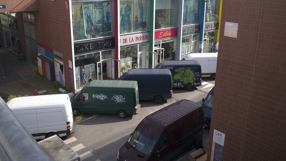 View of parked delivery vans and shops at the CIFA-Fashion Business Center