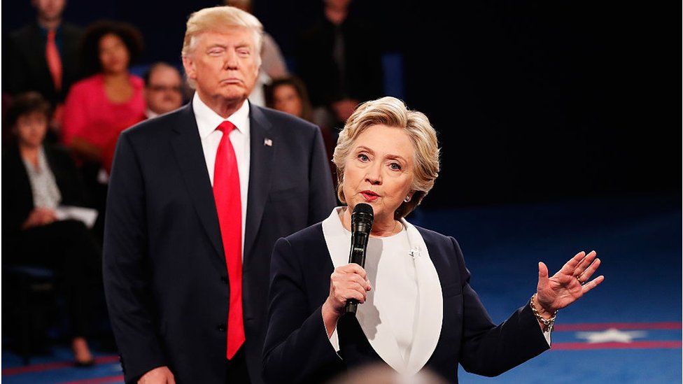 Democratic presidential nominee former Secretary of State Hillary Clinton (R) speaks as Republican presidential nominee Donald Trump looks on during the town hall debate at Washington University on October 9, 2016 in St Louis, Missouri
