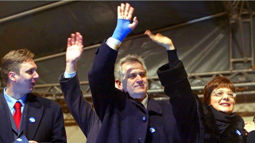 Deputy president of the ultranationalist Serbian Radical Party, Tomislav Nikolic (C) and party high officials, Maja Gojkovic (R) and Aleksandar Vucic (L) waves to their supporters at the party's final pre-election rally held in Novi Sad 23 December, 2003