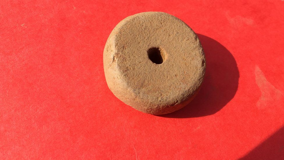 Stone wheel thought to be a spindle whorl for weaving.