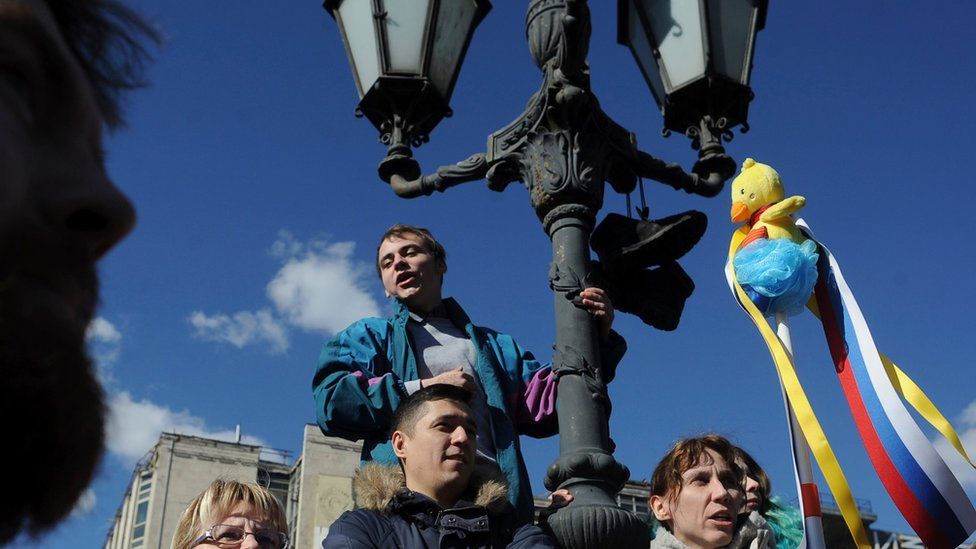 A woman holds up a yellow duck toy during protests in Moscow 26/03/2017