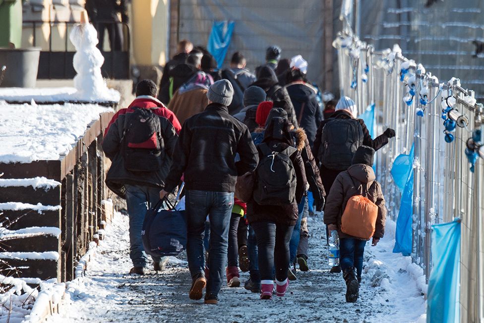 Беженцы (иммигранты, мигранты) идут к специальному поезду в Дюссельдорф на вокзале в Пассау, Германия, 16 января 2016 г.
