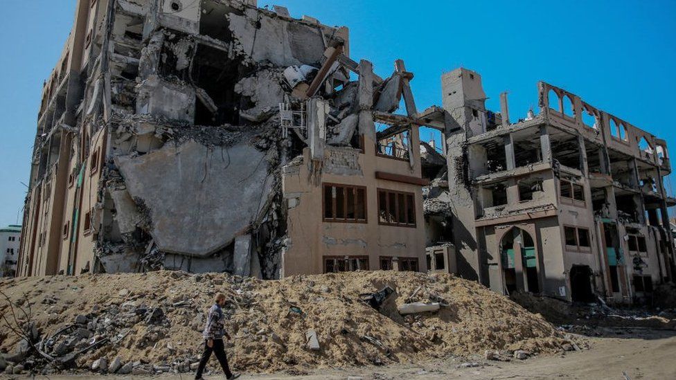 Man walks past ruins of Gaza City's Islamic University in February 2024