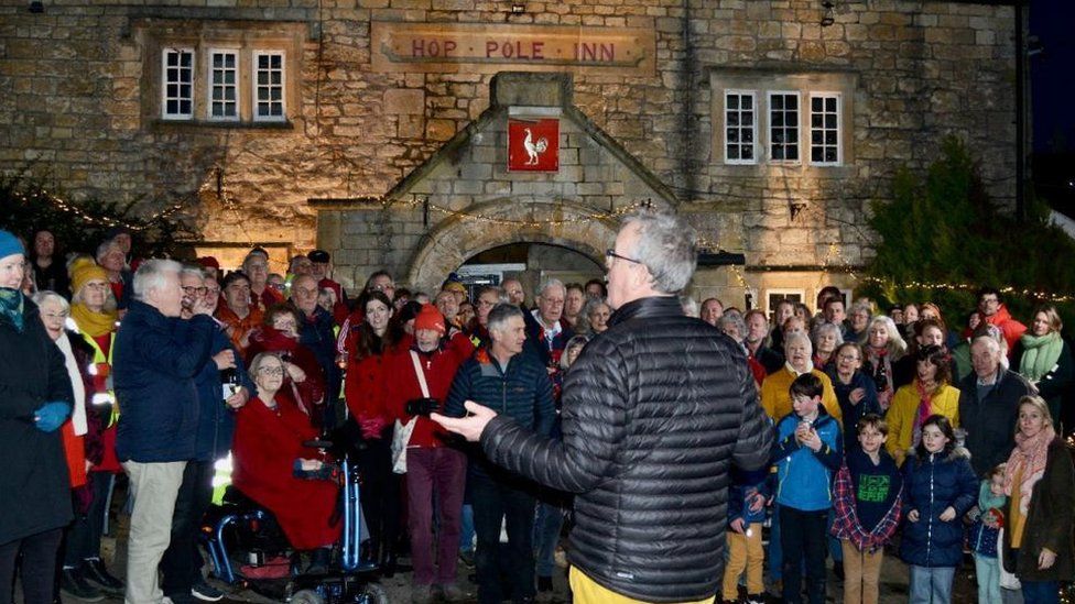 A group of people in front of the old pub