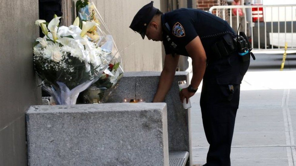 A police officer places a candle outside the 46th police precinct in New York City.