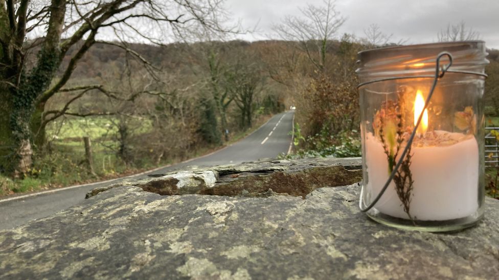 A single candle was lit overnight on the wall of a bridge where the crash happened
