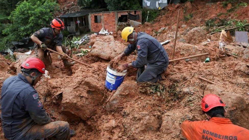 Firefighters dig for victims of a mudslide in Guarujá, São Paulo state, Brazil. Photo: 3 March 2020