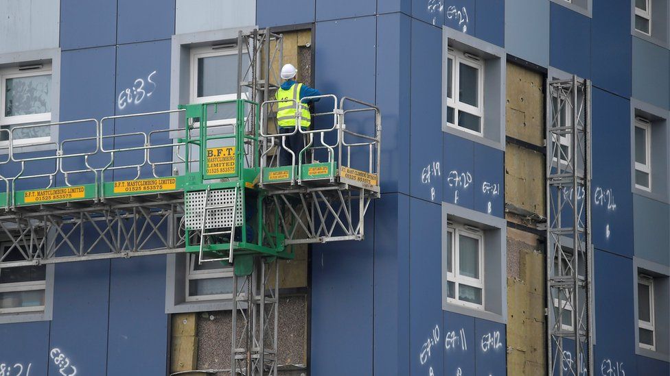 A worker removes cladding from a tower block in Cranford, west London