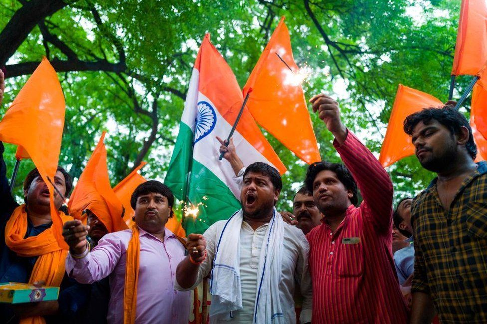 Members of Hindu Sena, a rightwing group, celebrate after the abolition of Article 370 in Delhi