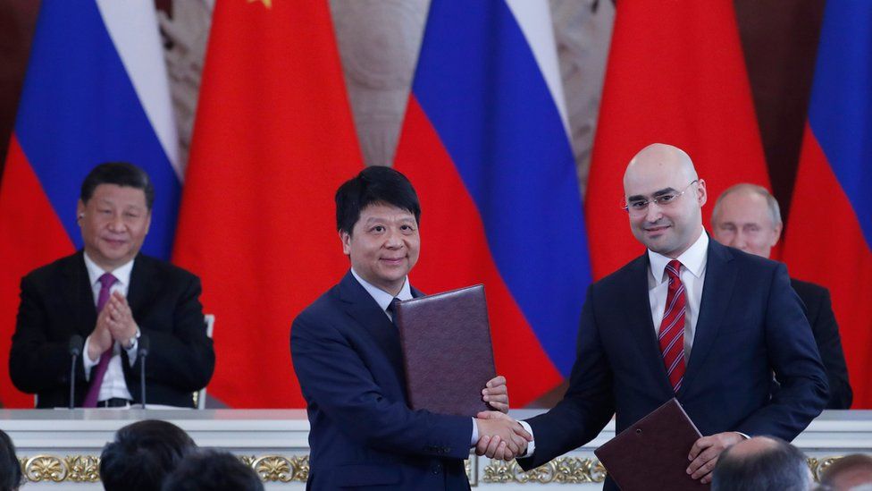 Chinese President Xi Jinping (L) and Russian President Vladimir Putin (R) applaud as Guo Ping (2L), Deputy Chairman of the Board and Rotating Chairman of Huawei, shakes hands with Alexei Kornya (2R), President and CEO of Russian mobile phone operator MTS, during a signing ceremony following Russian-Chinese talks at the Kremlin in Moscow on June 5, 2019.