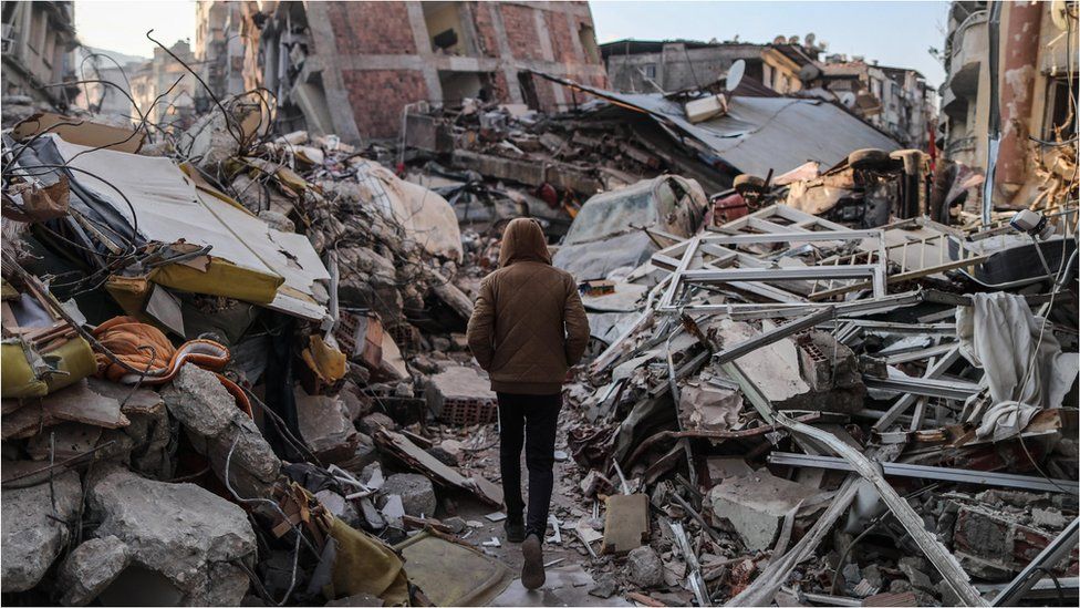 A person walks among the rubble in Hatay